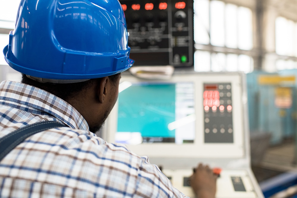 Engineer in hardhat viewing setups on monitor